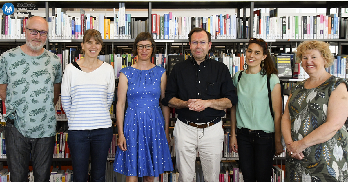 Die Gruppe der Kolleg*innen aus Frankreich vor einem großen Bücherregal.