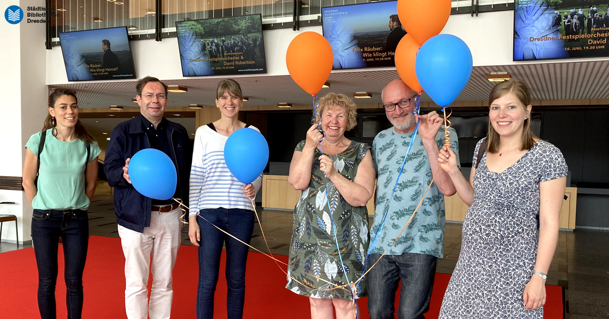 Die Kolleg*innen aus Frankreich im Erdgeschoss im Kulturpalast. Sie halten Luftballons in der Hand.