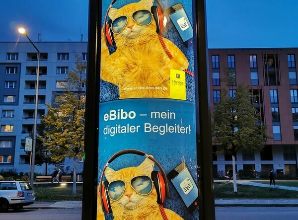 Foto einer Litfaßsäule mit zwei beleuchteten Werbeplakaten für die eBibo.