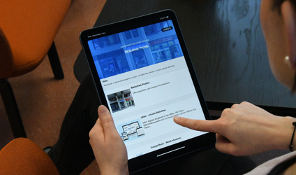 Eine Person hält einen eBook-Reader in der Hand und liest einen Text.