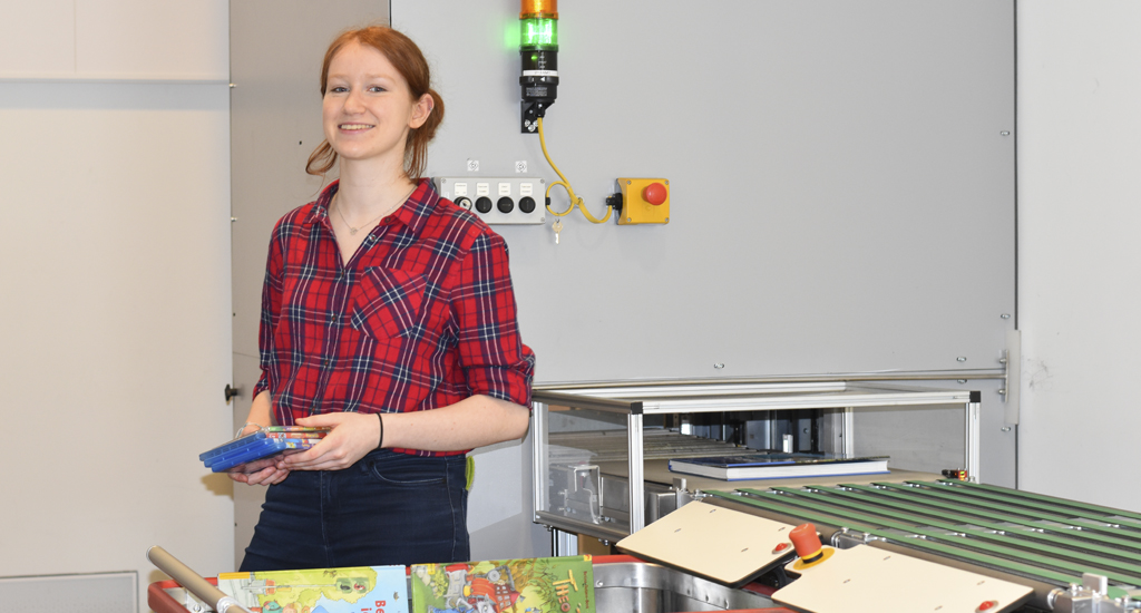 Eine junge Frau sortiert Bücher und Blurays Eine junge Frau sortiert Bücher und Blurays