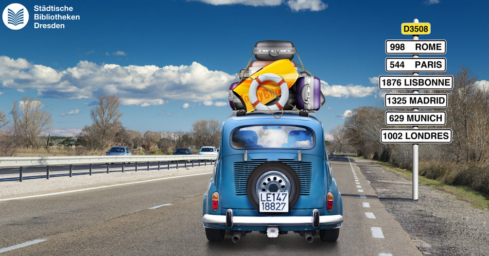 Ein blaues Auto fährt auf einer Autobahn und hat viel Gepäck auf dem Dach.