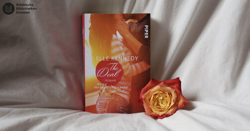 Das Buch "The Deal", daneben liegt eine Rose