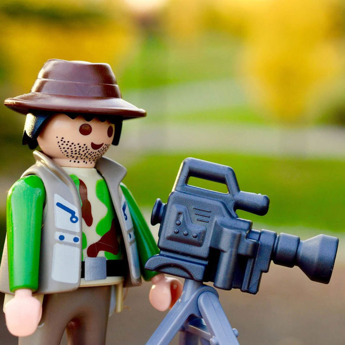 Eine Playmobil-Figur hält steht hinter einer Videokamera.