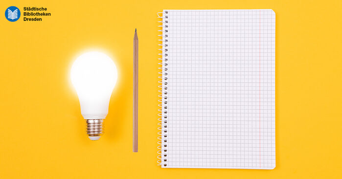 Glühbirne, Bleistift und Zeichenblock auf gelben Hintergund.