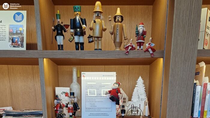 Regal mit Plakaten und Weihnachtskugeln